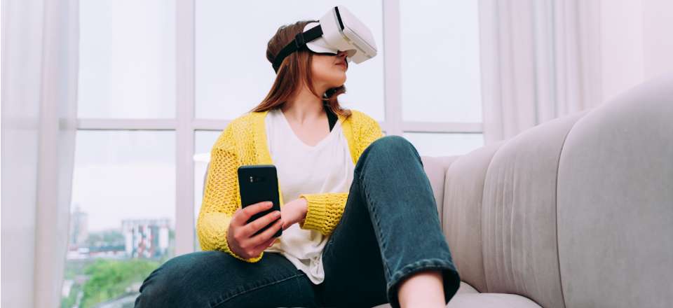 Mulher usando óculos de realidade aumentada  e celular na mão 